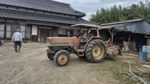 農家の敷地に停められた年季の入ったトラクター