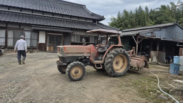 農家の敷地に停められた年季の入ったトラクター